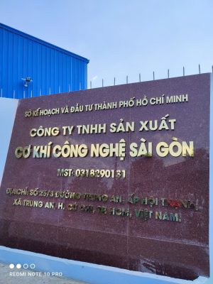 Bảng chữ inox vàng xước trên nền vách đá