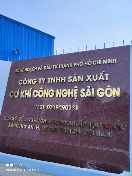 Bảng chữ inox vàng xước trên nền vách đá