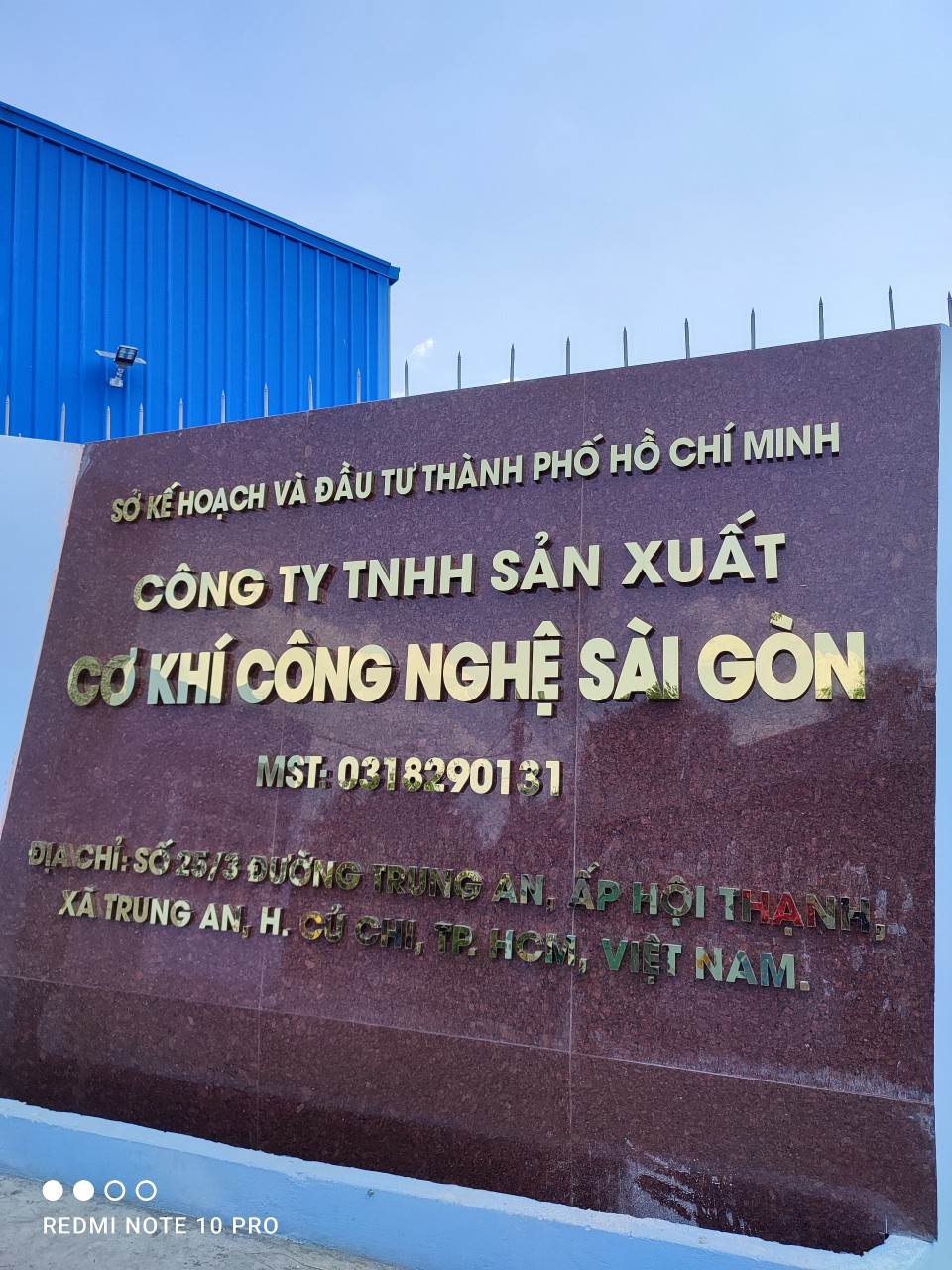 Bảng chữ inox vàng xước trên nền vách đá